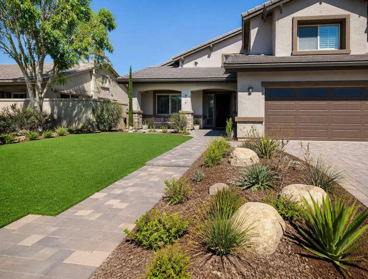 Front yard synthetic grass installation with a paver walkway in Riverside CA